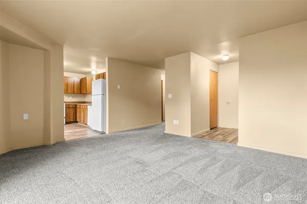 a view of an empty room with a kitchen