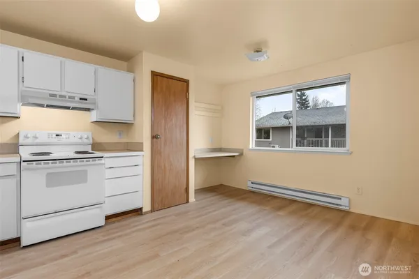 a kitchen with granite countertop white cabinets and white appliances