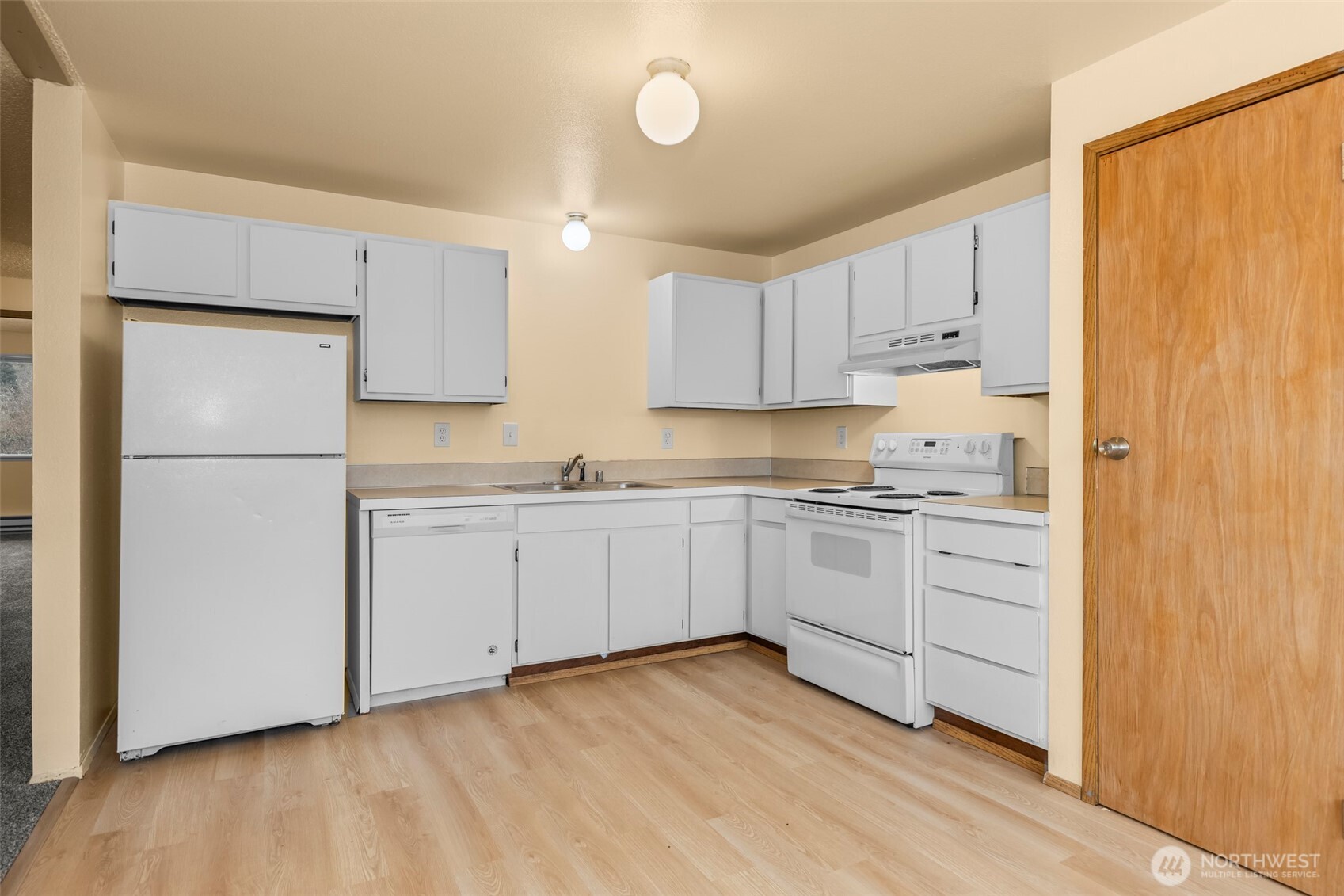 15912 Elm Street East Sumner, WA 98390 - Photo 9 of 30 a kitchen with white cabinets and white appliances
