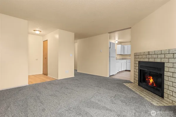 a view of an empty room with fireplace and a window