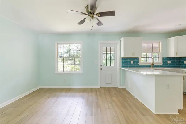 a view of a kitchen with a sink dishwasher a kitchen island with wooden floor and cabinets