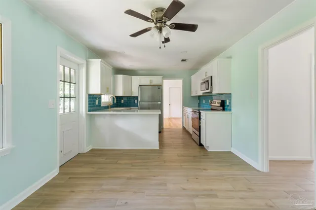 a kitchen with kitchen island a refrigerator a stove and cabinets
