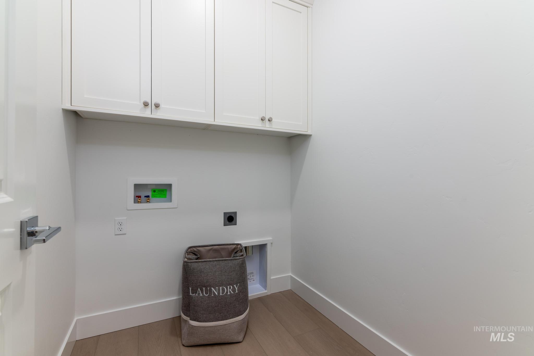 1907 West Blue Lightning Street Middleton, ID 83644 - Photo 10 of 11 Laundry room with hookup for an electric dryer, light wood-style floors, washer hookup, and cabinet space