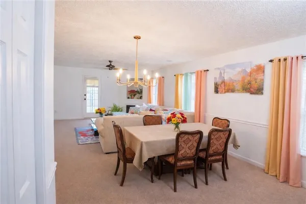 a view of a dining room with furniture and a chandelier