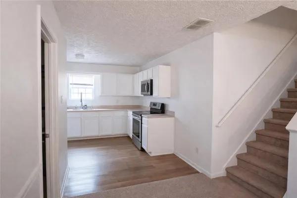 a kitchen with white cabinets and white appliances