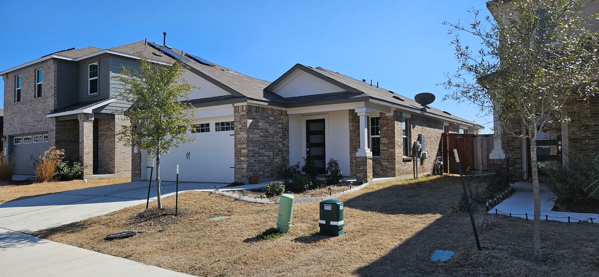 215 Canley Loop Hutto, TX 78634 - Photo 1 of 13 View of front of home with brick siding, concrete driveway, and solar panels