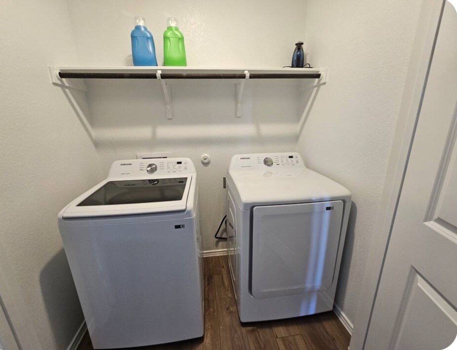 215 Canley Loop Hutto, TX 78634 - Photo 11 of 13 Laundry area featuring a textured wall, dark wood-style floors, and independent washer and dryer