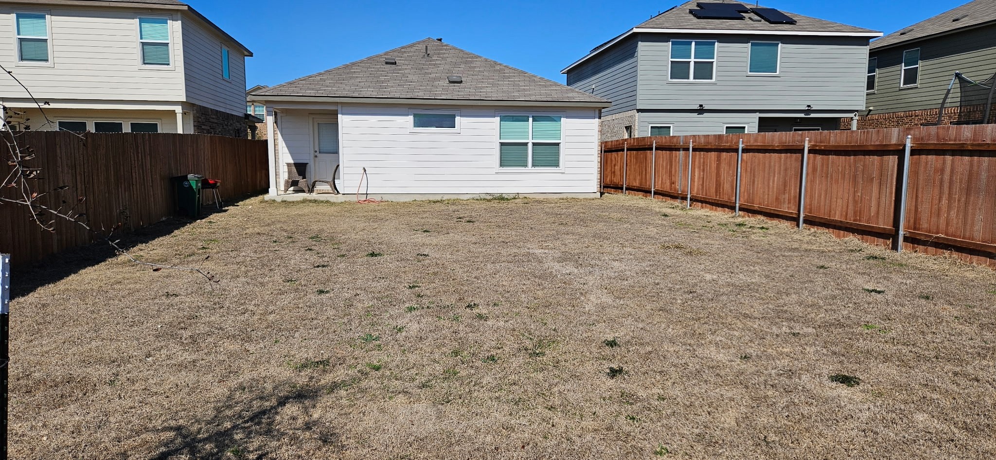 215 Canley Loop Hutto, TX 78634 - Photo 12 of 13 Back of house with a fenced backyard and roof with shingles