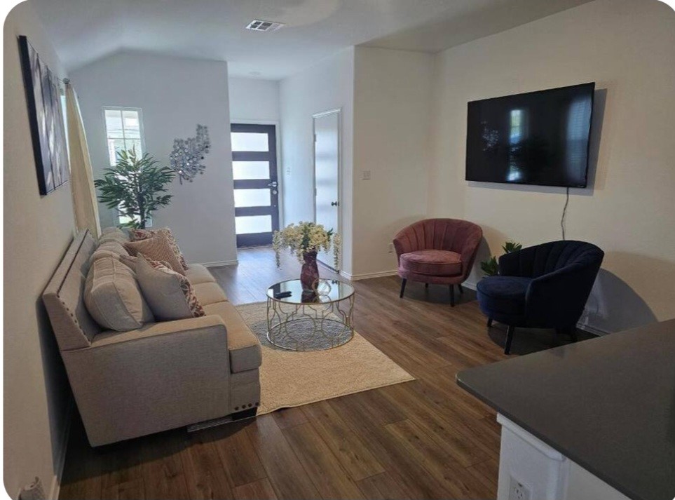 215 Canley Loop Hutto, TX 78634 - Photo 3 of 13 Living room featuring dark wood-style flooring and vaulted ceiling