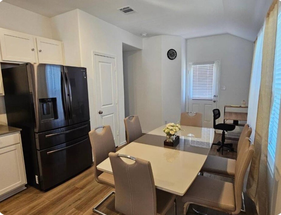 215 Canley Loop Hutto, TX 78634 - Photo 4 of 13 Dining area with dark wood-style flooring and vaulted ceiling