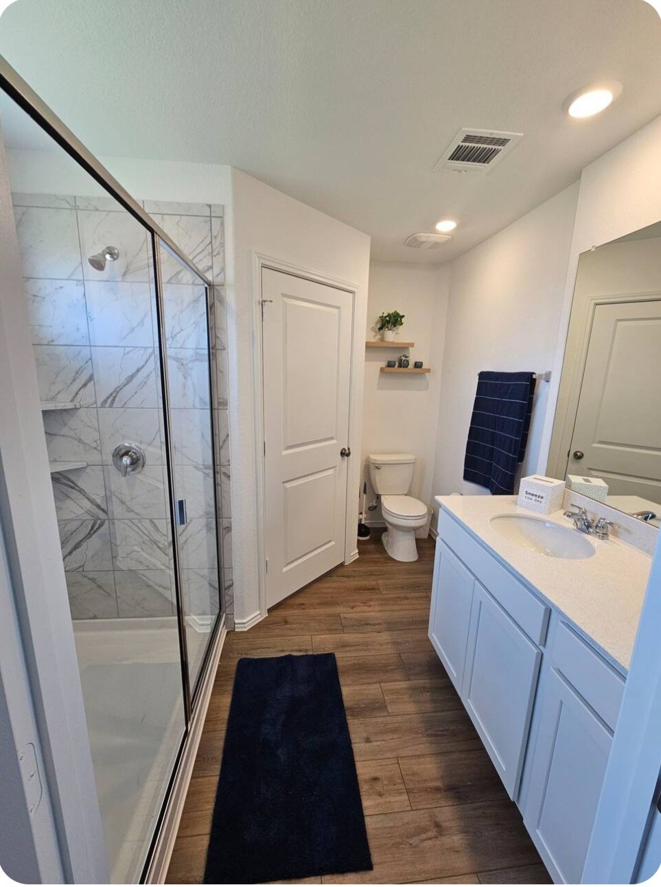 215 Canley Loop Hutto, TX 78634 - Photo 7 of 13 Full bath featuring a marble finish shower, vanity, and dark wood-style flooring