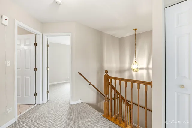 a view of a hallway with wooden floor and windows