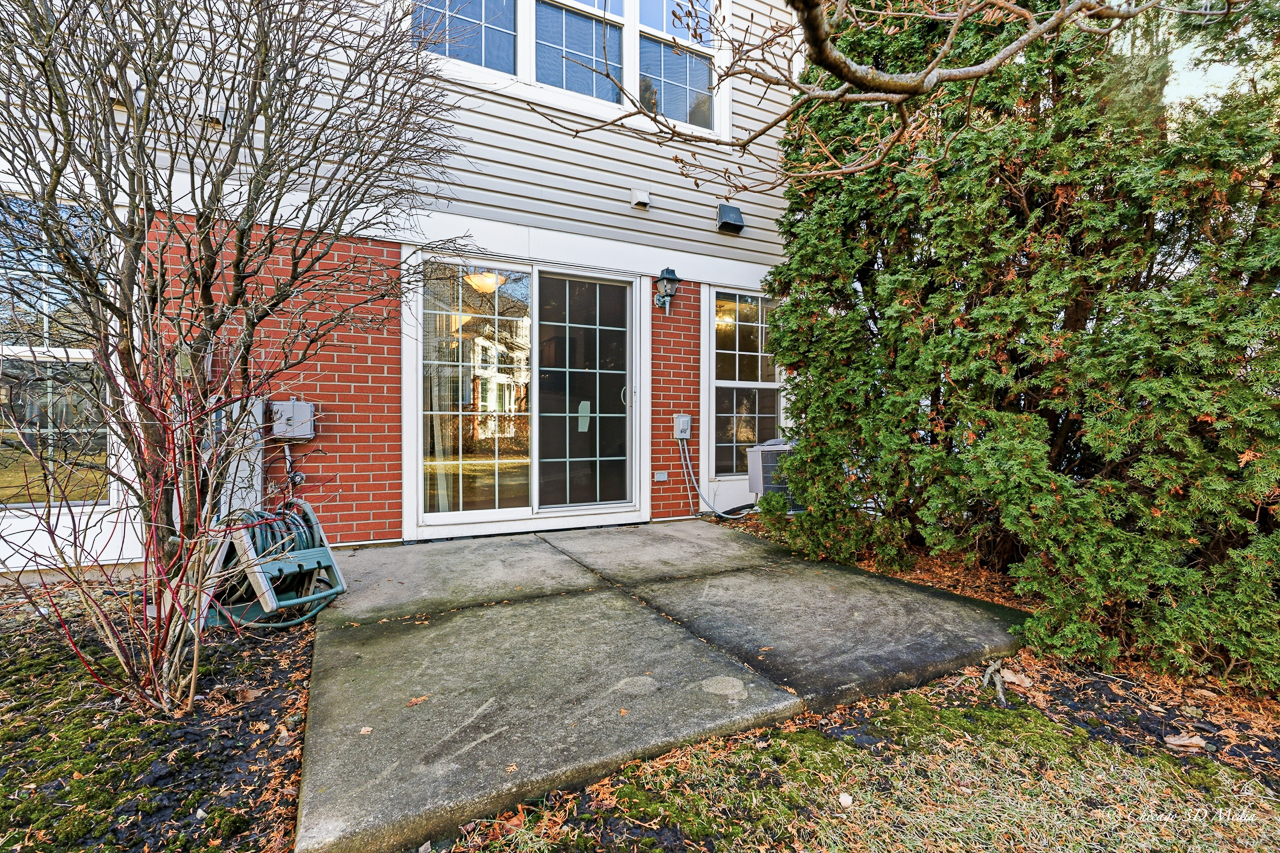812 Old Checker Road Buffalo Grove, IL 60089 - Photo 23 of 26 a front view of a house with a yard and potted plants