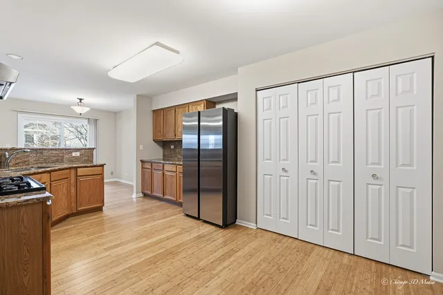 a view of a kitchen with refrigerator and wooden floor