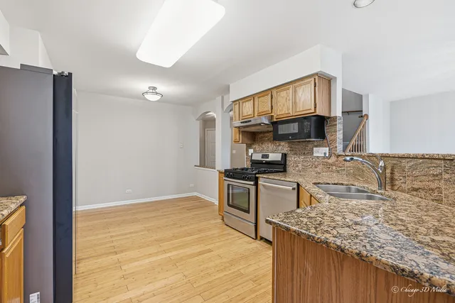 a kitchen with stainless steel appliances granite countertop a sink stove and refrigerator