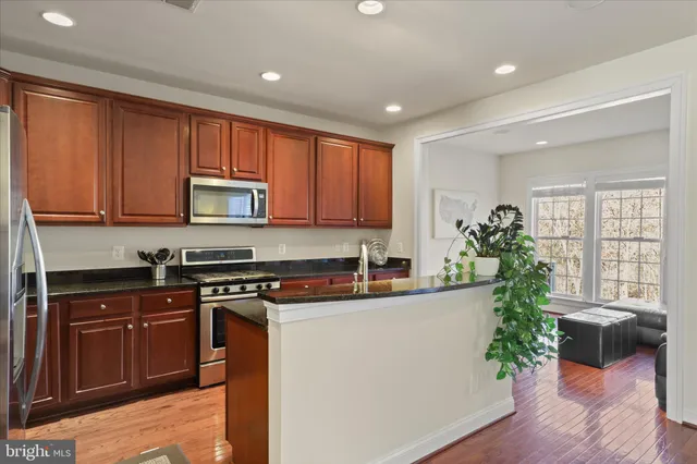 a kitchen with a refrigerator and a stove top oven