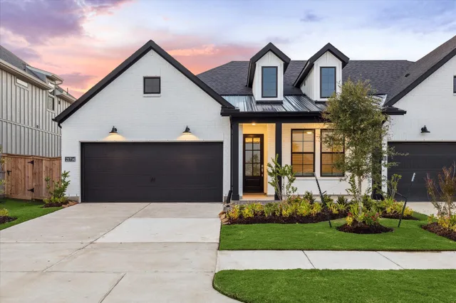 a front view of a house with a garden and plants