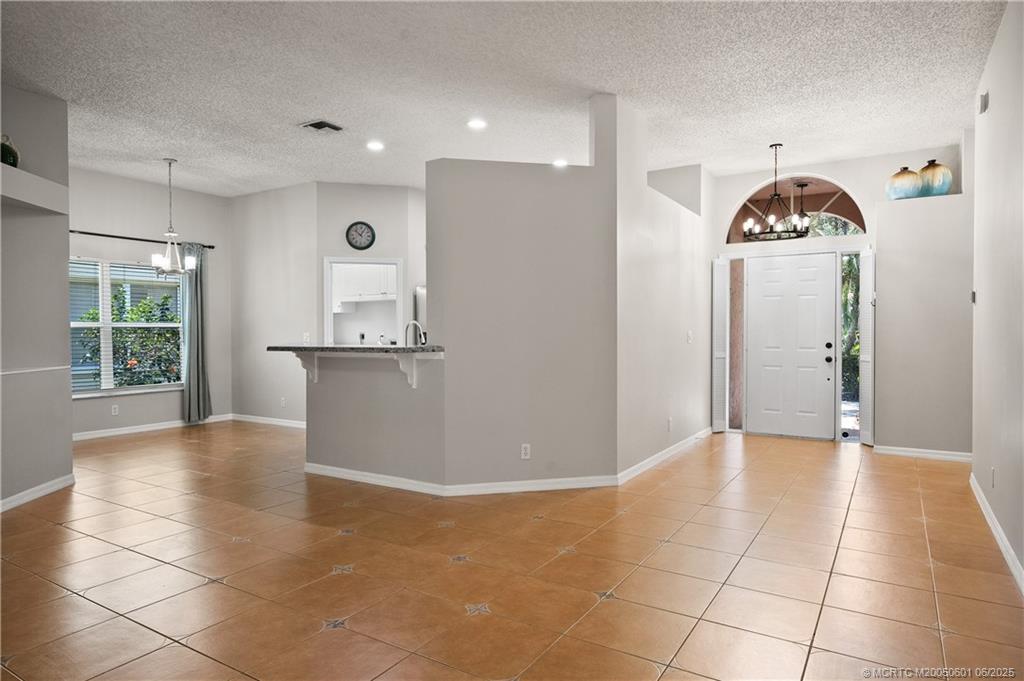 7221 Southeast Seagate Lane Stuart, FL 34997 - Photo 11 of 51 a view of a hallway with entryway and chandelier