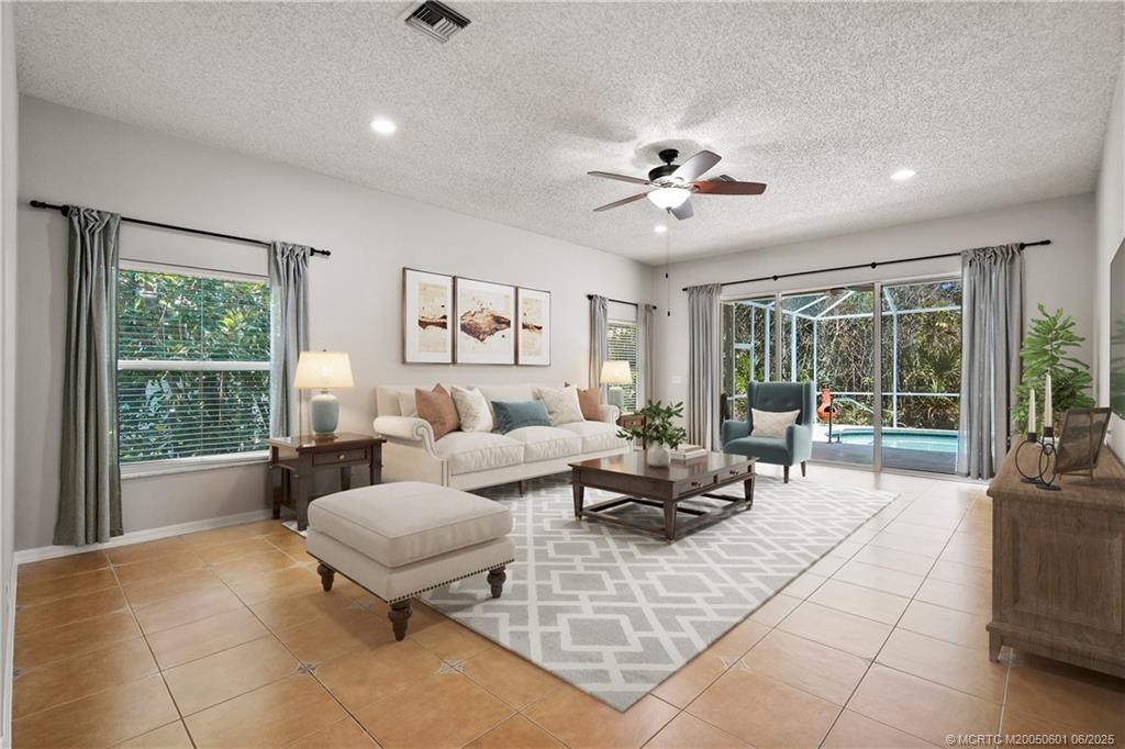 7221 Southeast Seagate Lane Stuart, FL 34997 - Photo 12 of 51 a living room with furniture and floor to ceiling windows