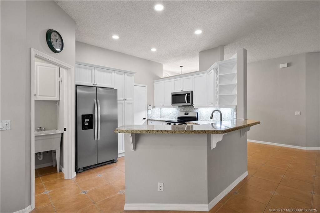 7221 Southeast Seagate Lane Stuart, FL 34997 - Photo 19 of 51 a kitchen with stainless steel appliances a sink stove and refrigerator
