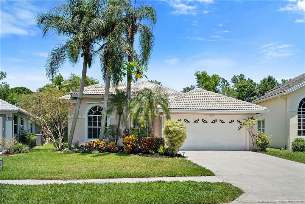 7221 Southeast Seagate Lane Stuart, FL 34997 - Photo 2 of 51 front view of a house with a garden