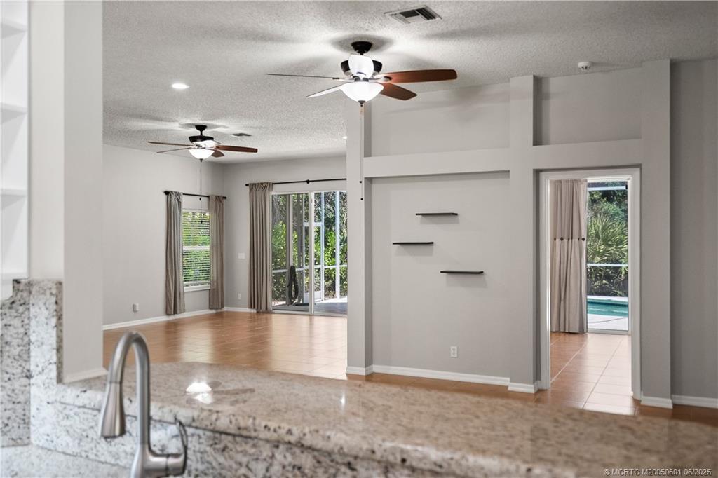 7221 Southeast Seagate Lane Stuart, FL 34997 - Photo 23 of 51 a view of a livingroom with a chandelier fan and windows