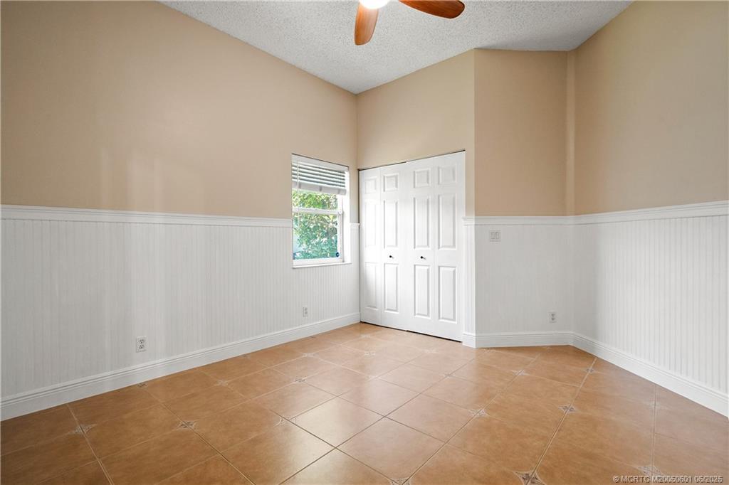 7221 Southeast Seagate Lane Stuart, FL 34997 - Photo 31 of 51 an empty room with windows and chandelier fan