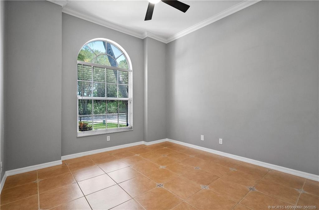 7221 Southeast Seagate Lane Stuart, FL 34997 - Photo 32 of 51 an empty room with windows and ceiling fan