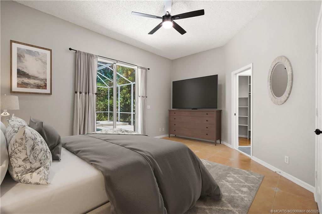 7221 Southeast Seagate Lane Stuart, FL 34997 - Photo 4 of 51 a bedroom with a bed and a flat screen tv