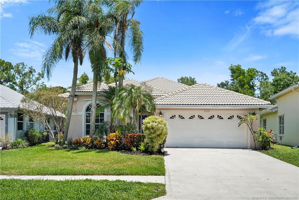 7221 Southeast Seagate Lane Stuart, FL 34997 - Photo 7 of 51 a front view of a house with a garden