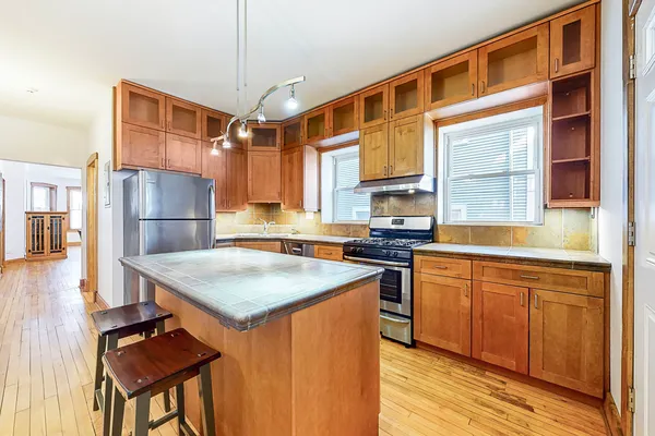 a kitchen with stainless steel appliances granite countertop a sink and a refrigerator