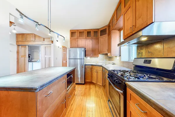 a kitchen with stainless steel appliances granite countertop a sink stove and refrigerator