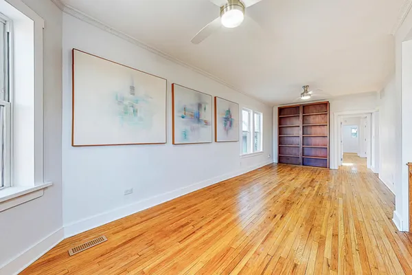 a view of empty room with wooden floor and window