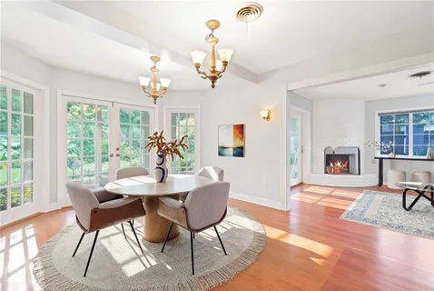 a dining room with furniture a chandelier and wooden floor