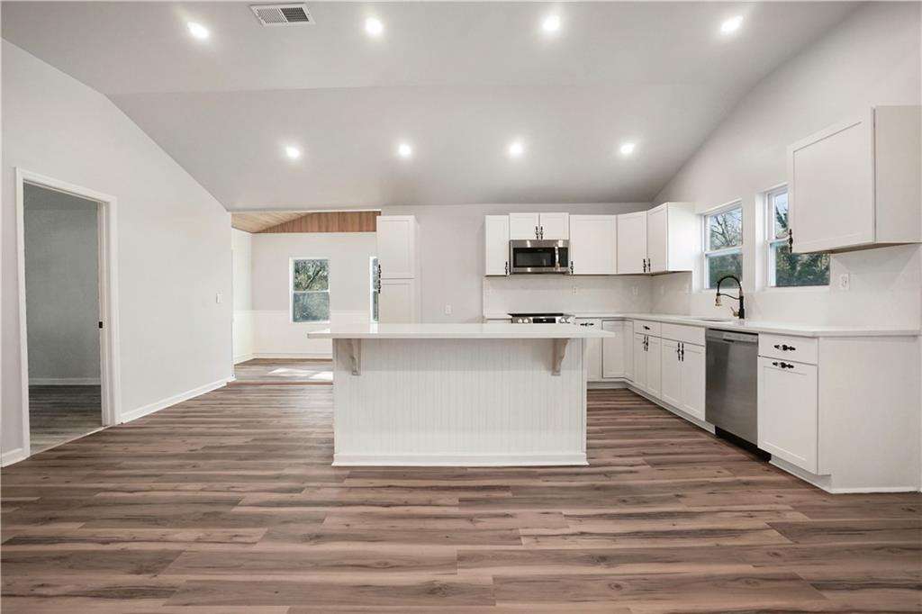 1004 Mapp Street Madison, GA 30650 - Photo 12 of 30 a large kitchen with kitchen island white cabinets and stainless steel appliances