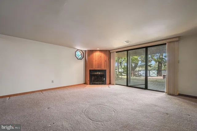 a view of an empty room with a fireplace and a window