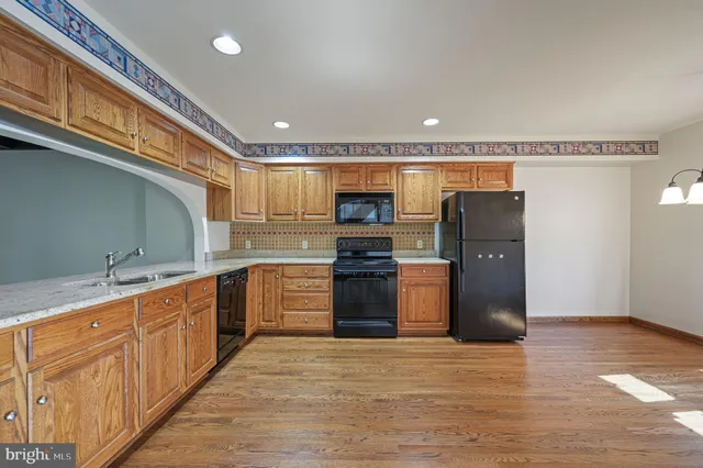 a kitchen with stainless steel appliances granite countertop a refrigerator and a stove top oven