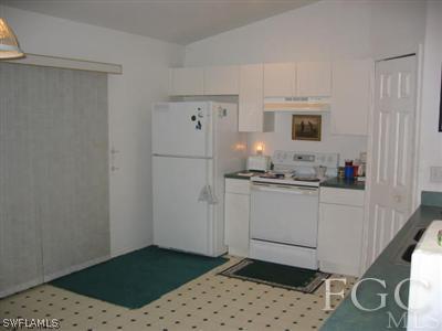 2010 Park Road Lehigh Acres, FL 33971 - Photo 2 of 9 a kitchen with a sink a stove and white cabinets