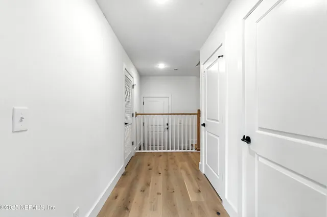 a view of an empty room with wooden floor and windows