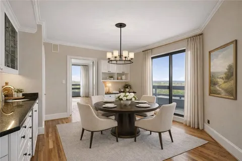 a view of a dining room with furniture a chandelier and wooden floor