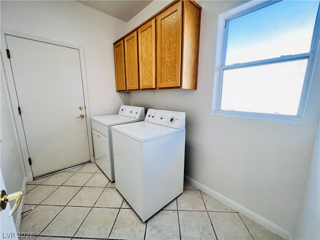 3047 Hickory Valley Road Henderson, NV 89052 - Photo 24 of 33 Functional utility space with tile flooring, featuring ample cabinet storage and a sun-filled window.