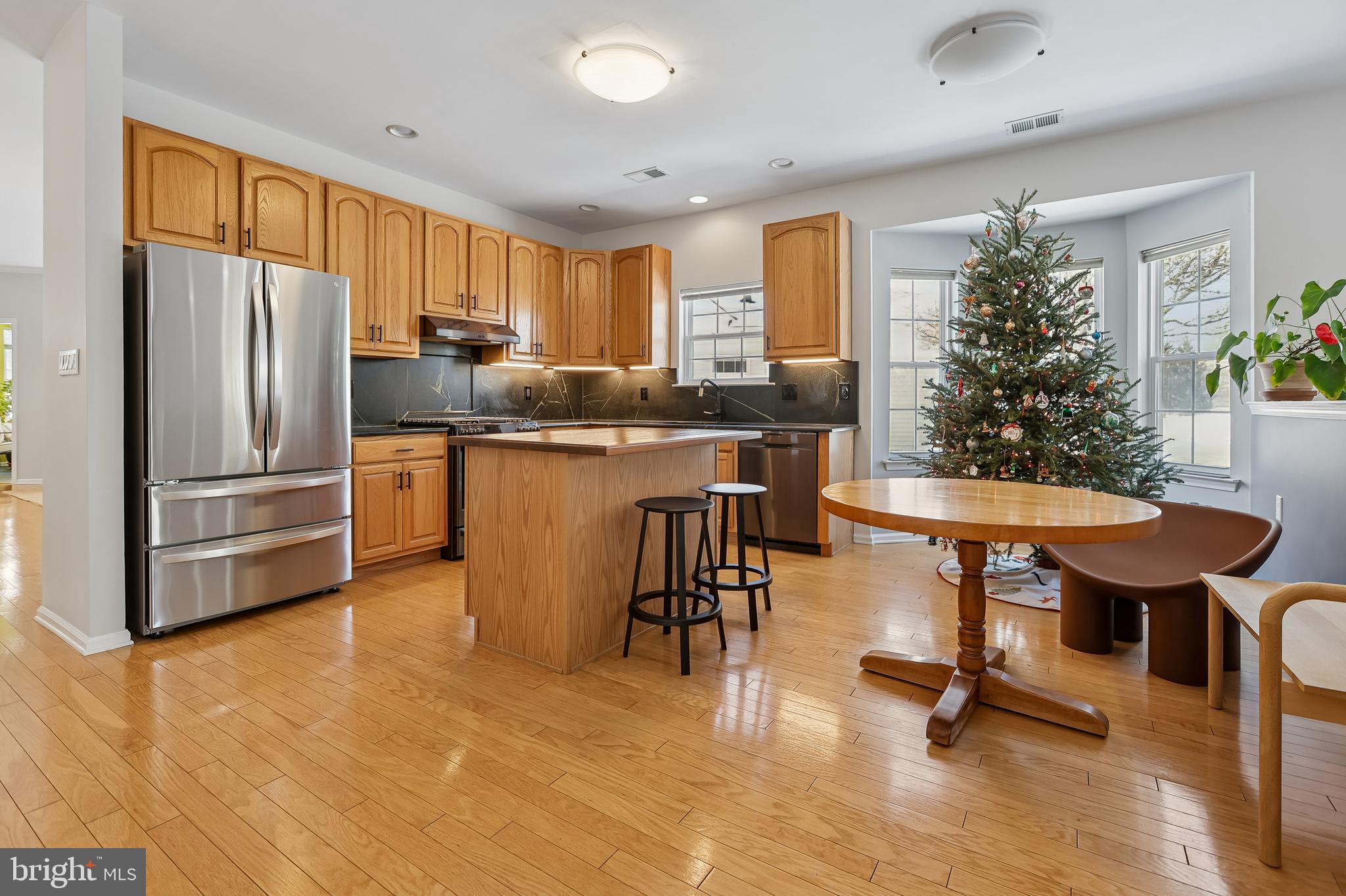 17 Pinflower Lane Princeton Junction, NJ 08550 - Photo 8 of 57 a kitchen with stainless steel appliances granite countertop a refrigerator a stove a dining table and chairs with wooden floor
