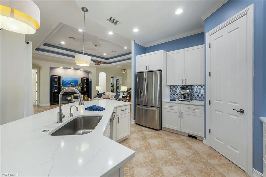 7688 Cottesmore Drive Naples, FL 34113 - Photo 12 of 45 a kitchen with refrigerator a sink and cabinets