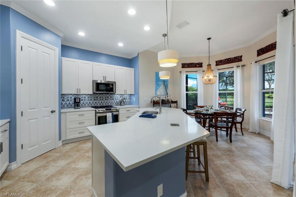 7688 Cottesmore Drive Naples, FL 34113 - Photo 14 of 45 a large kitchen with cabinets table and chairs