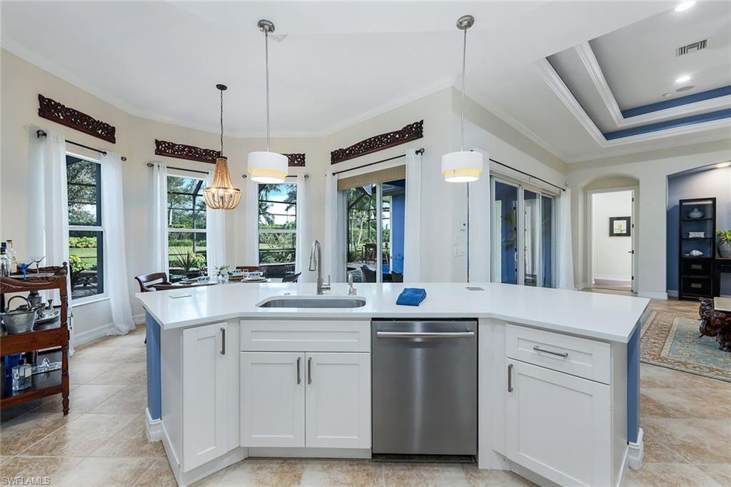 7688 Cottesmore Drive Naples, FL 34113 - Photo 15 of 45 a large white kitchen with a large window and stainless steel appliances