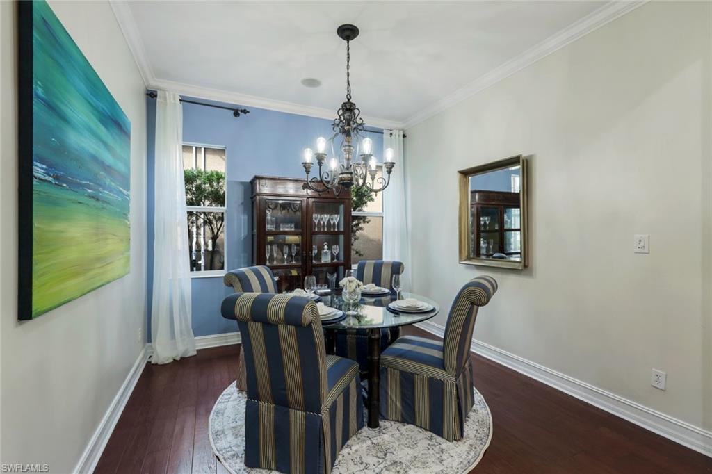 7688 Cottesmore Drive Naples, FL 34113 - Photo 19 of 45 a dining room with furniture a chandelier and wooden floor