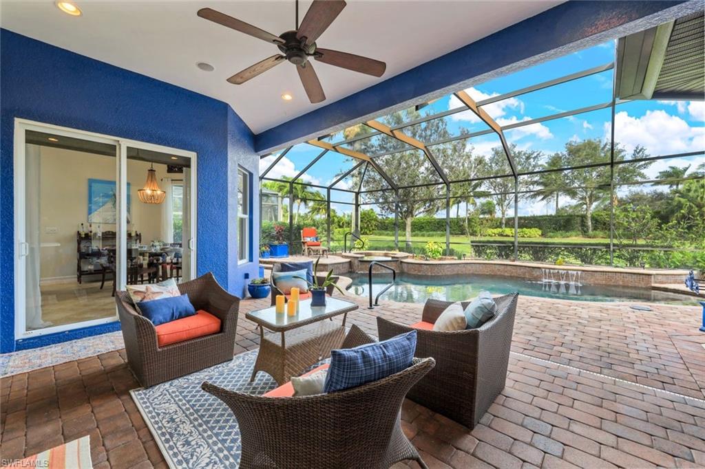7688 Cottesmore Drive Naples, FL 34113 - Photo 2 of 45 a living room with patio furniture and a floor to ceiling window