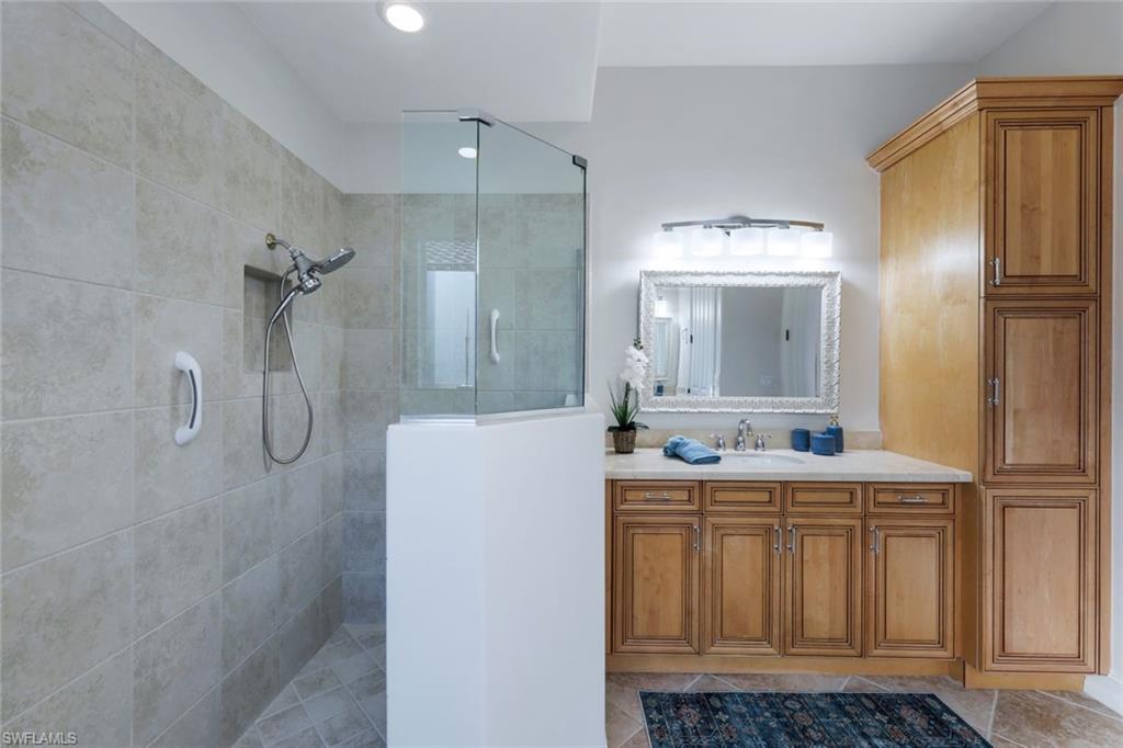 7688 Cottesmore Drive Naples, FL 34113 - Photo 22 of 45 a bathroom with a granite countertop sink and a mirror