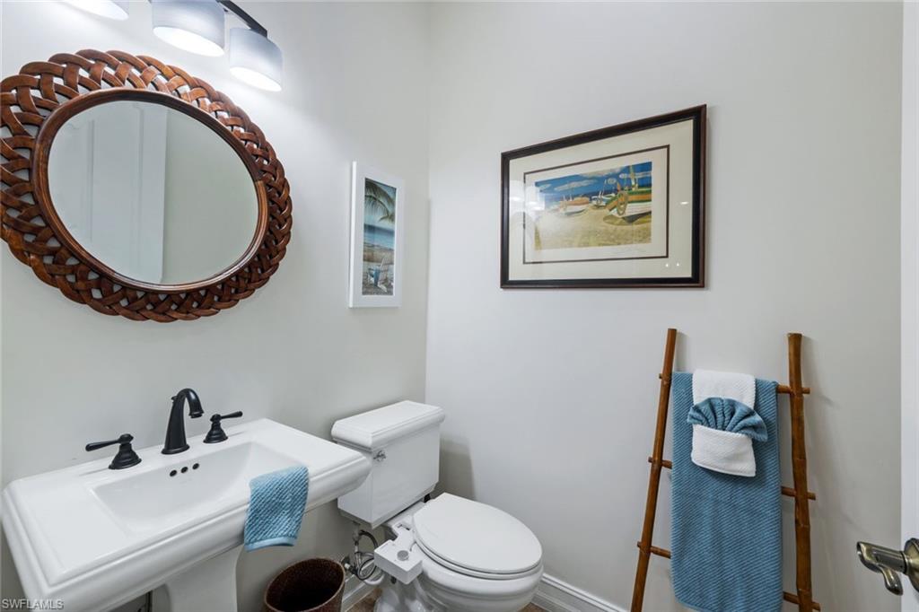 7688 Cottesmore Drive Naples, FL 34113 - Photo 27 of 45 a bathroom with a toilet a sink and a mirror