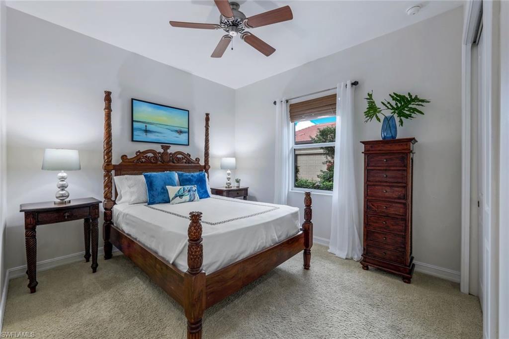 7688 Cottesmore Drive Naples, FL 34113 - Photo 28 of 45 a bedroom with a bed and a lamp on dresser